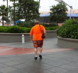 Not too stylish, but comfortable for theme parks with loose fitting t-shirt, loose shorts, and sneakers with socks.  He also gets points for standing out in a crowd. 