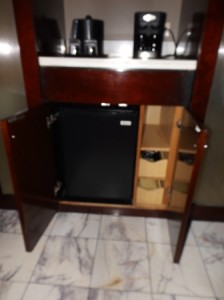 Small fridge suitable for bottled water.  Drawers on right hold coffee supplies.  This is a pod coffeemaker and makes one cup.  