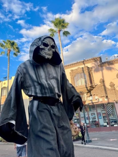 Costumed Scareactor walks on stilts through a Scare Zone at Halloween Horror Nights