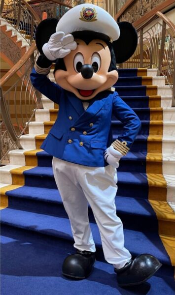 Captain Mickey on a Disney Cruise Line ship, dressed in his captain’s uniform and welcoming guests.
